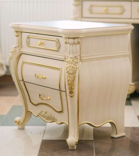 Тумба прикроватная Милан привлекает нестандартной формой, резным декором с позолотой и фигурными изогнутыми ножками. Состоит из трех выдвижных ящиков со специальными механизмами для удобного открывания и закрывания.