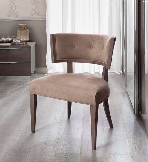 Пуфик на ножках станет удобным местом для сиденья в спальне.